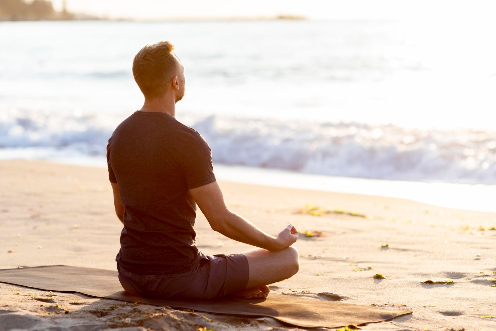 Man meditates on the beach